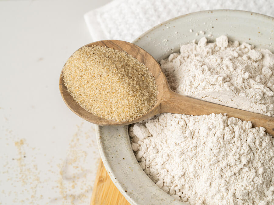 Bowl of fonio flour with a spoon of fonio grain